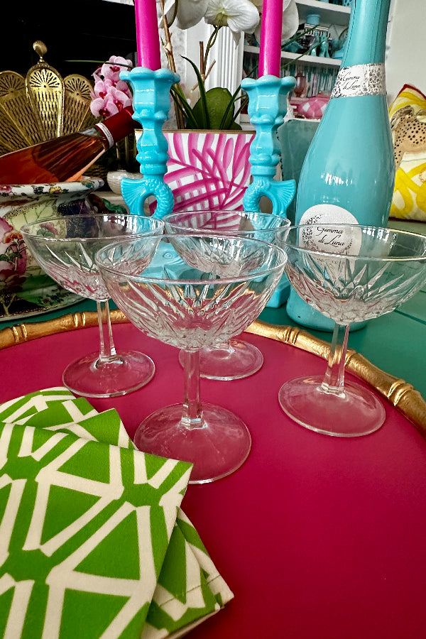 Vintage Crystal Champagne Coupes styled on a pink tray with cocktail napkins
