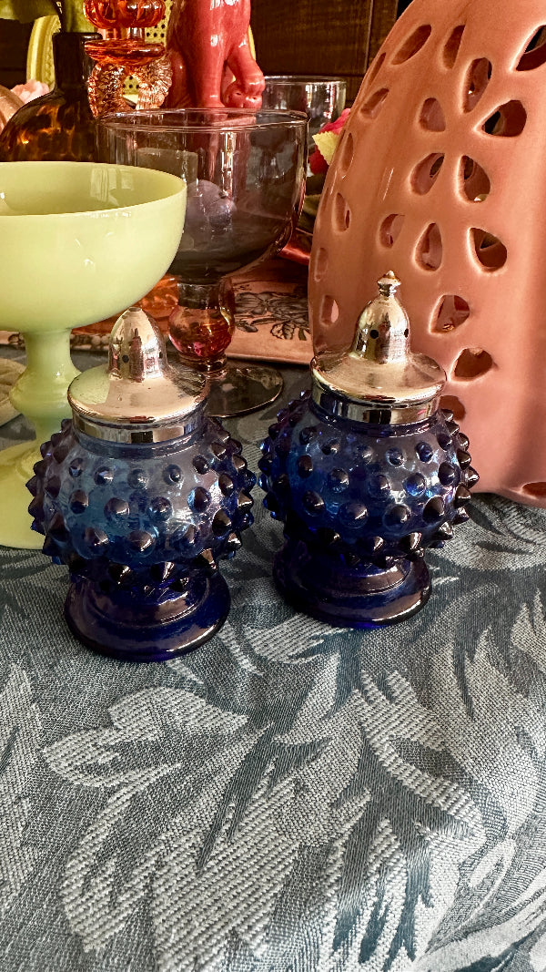 Vintage Hobnail Salt and Pepper Shakers in blue glass with silver tops displayed on a styled table