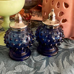 Vintage Hobnail Salt and Pepper Shakers in blue glass with silver tops displayed on a styled table