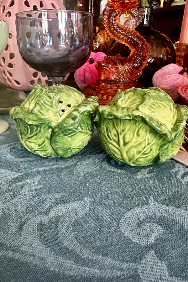 Vintage Salt and Pepper Shakers in green and white cabbage leaf style displayed on a table.