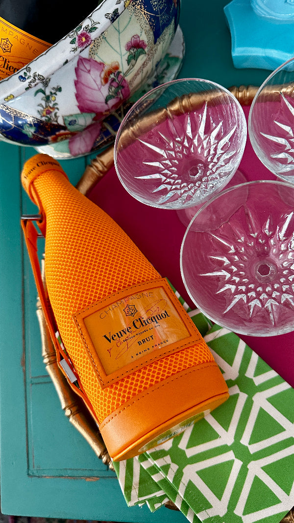 orange wine bottle cover with vintage champagne coupes
