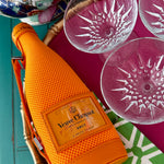 orange wine bottle cover with vintage champagne coupes