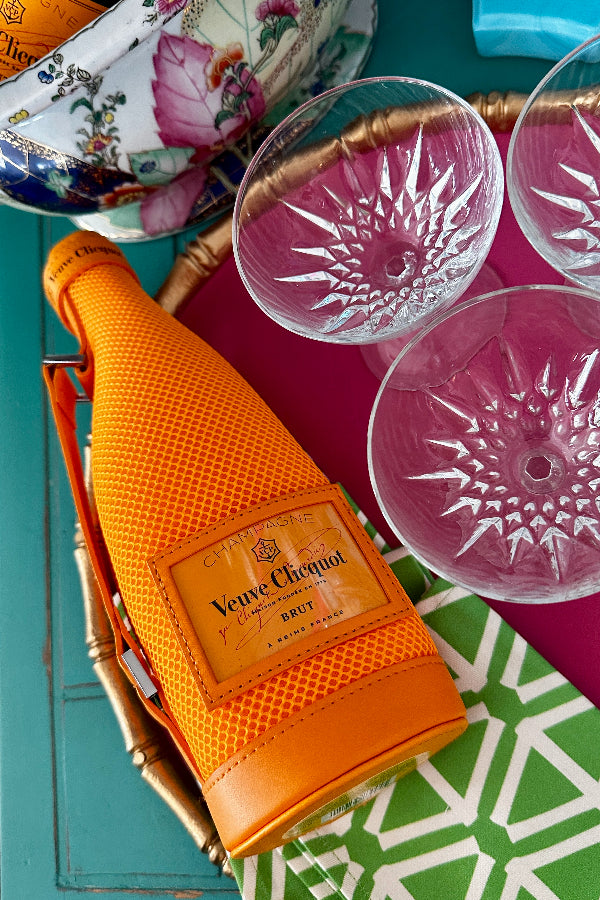 orange wine bottle cover with vintage champagne coupes